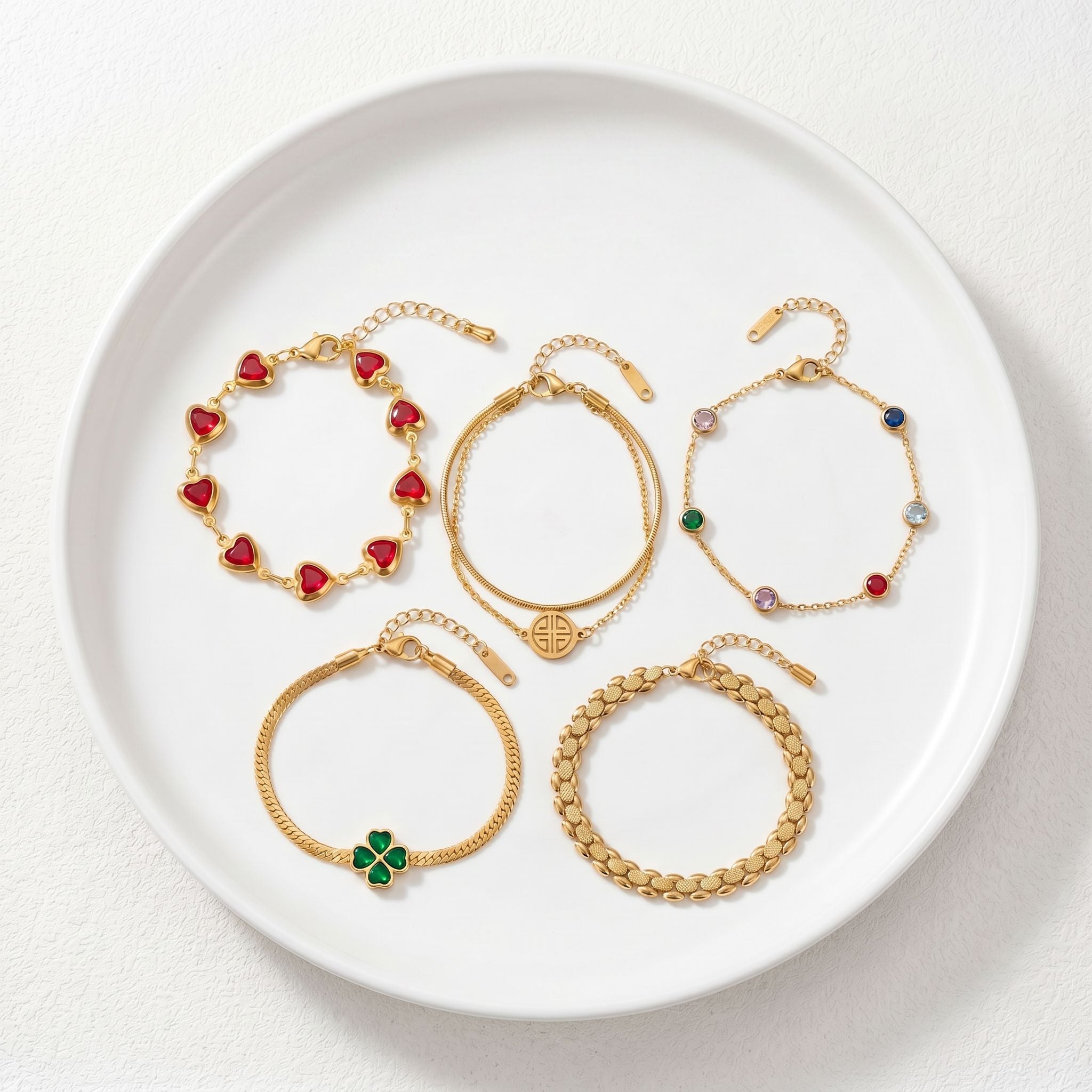 Delicate gold chain bracelet with heart charm and small clear gemstone accents on light surface