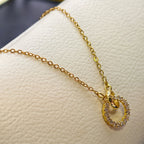 Gold necklace with a circular pendant on a white surface