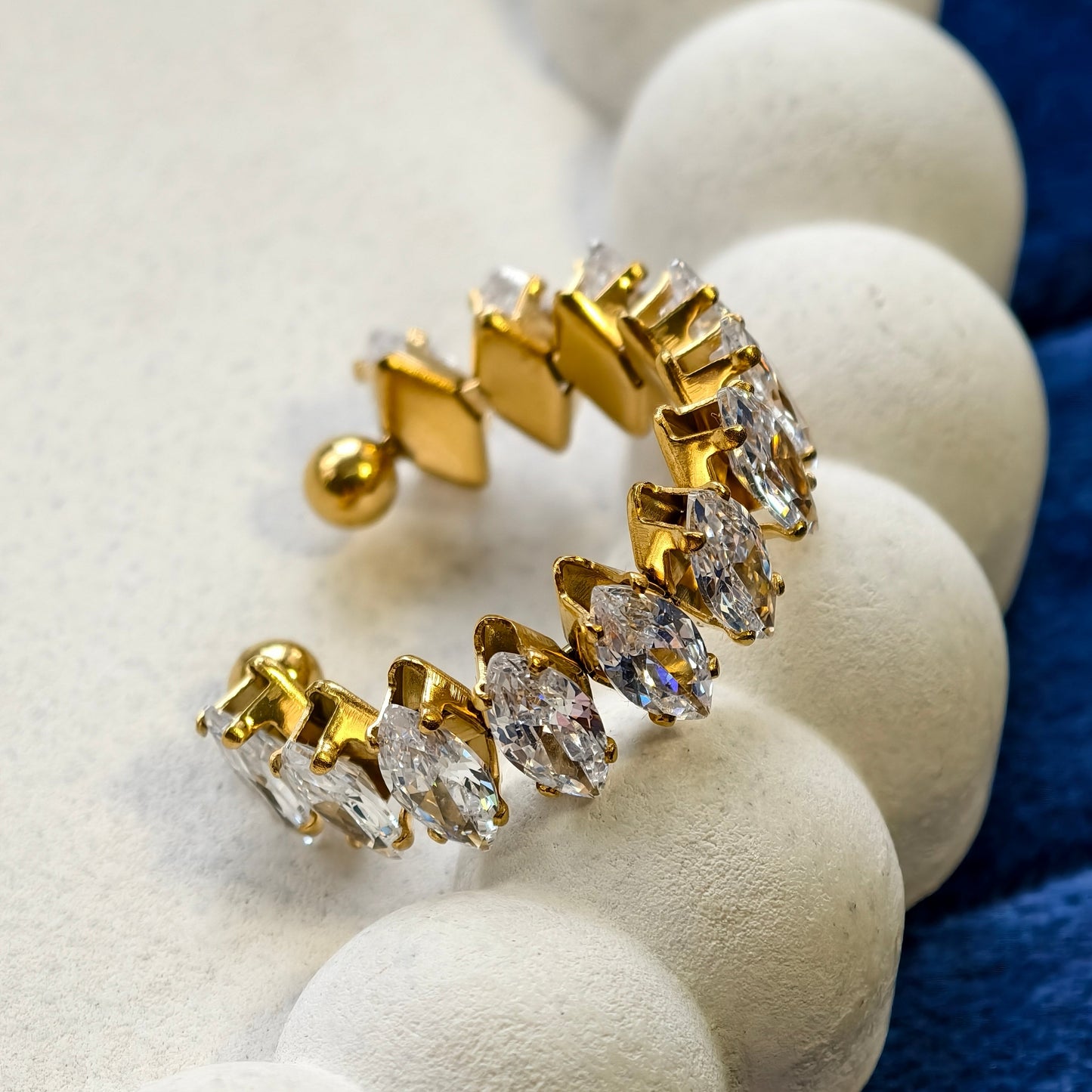 Gold and diamond ring on a white stone surface