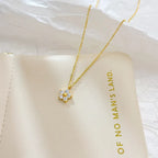 Pretty Shimmering Things gold-tone floral pendant necklace with cubic zirconia petals and a central gold bead.