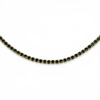 Pretty Shimmering Things Global gold-tone tennis necklace featuring a row of sparkling jet black crystals.