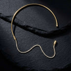 Pretty Shimmering Things Global gold-tone rigid collar necklace with a detachable sparkling crystal tennis chain.
