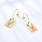 Pretty Shimmering Things Global gold-plated drop earrings featuring a vibrant, multi-colored leaf motif on rectangles.