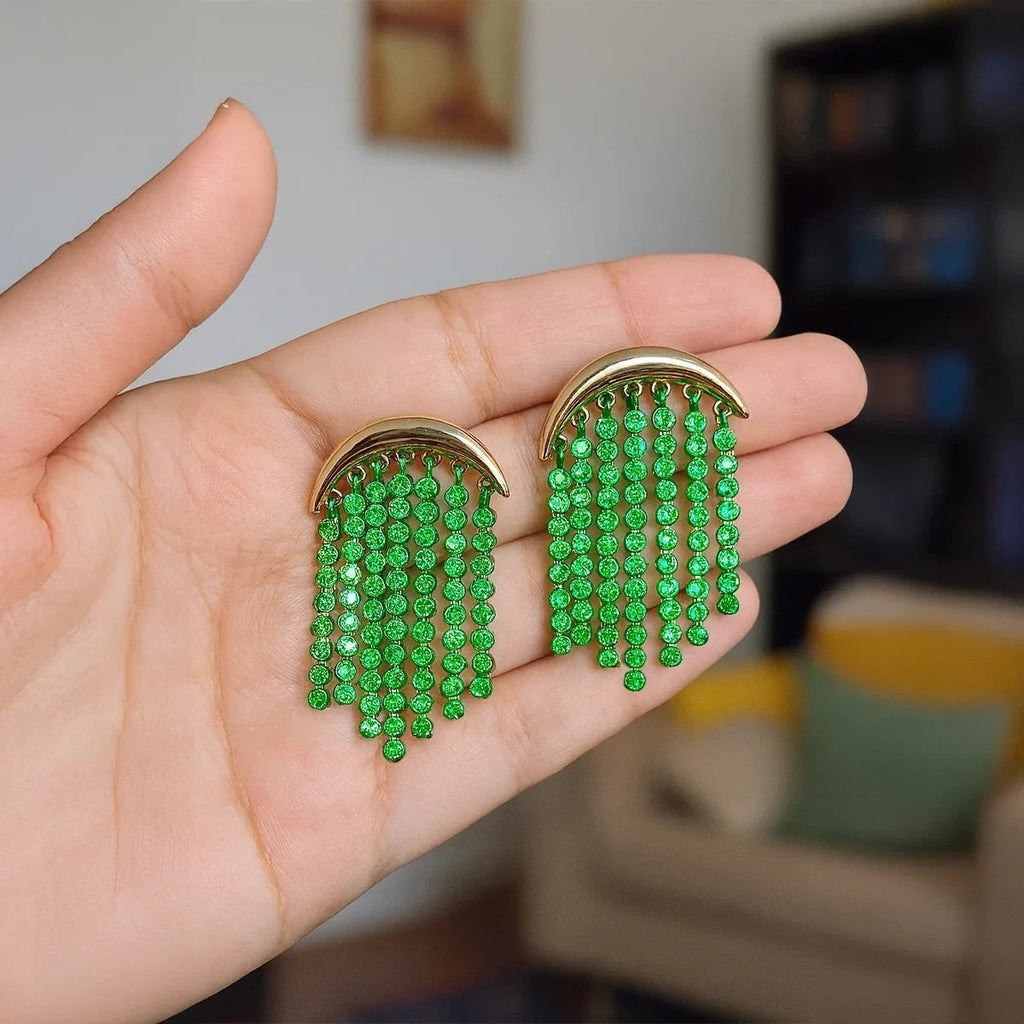 Pretty Shimmering Things Global crescent fringe earrings with gold-tone arches and cascading green crystal strands.
