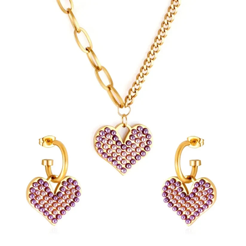 Pretty Shimmering Things Global Chloe heart charm jewelry set featuring gold-tone chains and purple pearl accents.