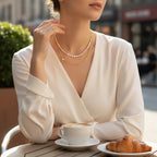 Pretty Shimmering Things Global layered gold-tone necklace with crystal-encrusted strand worn by a woman at a cafe.