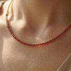 Pretty Shimmering Things Global convertible gold-tone necklace with a ruby red crystal tennis chain attachment.