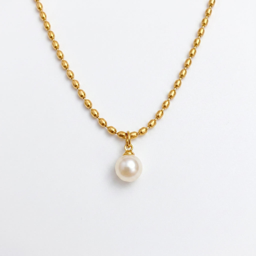 Pretty Shimmering Things gold-toned beaded chain necklace with a single lustrous white pearl pendant.
