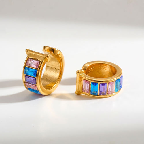 Pretty Shimmering Things gold-tone huggie hoop earrings with pink, blue, and purple baguette-cut crystals.