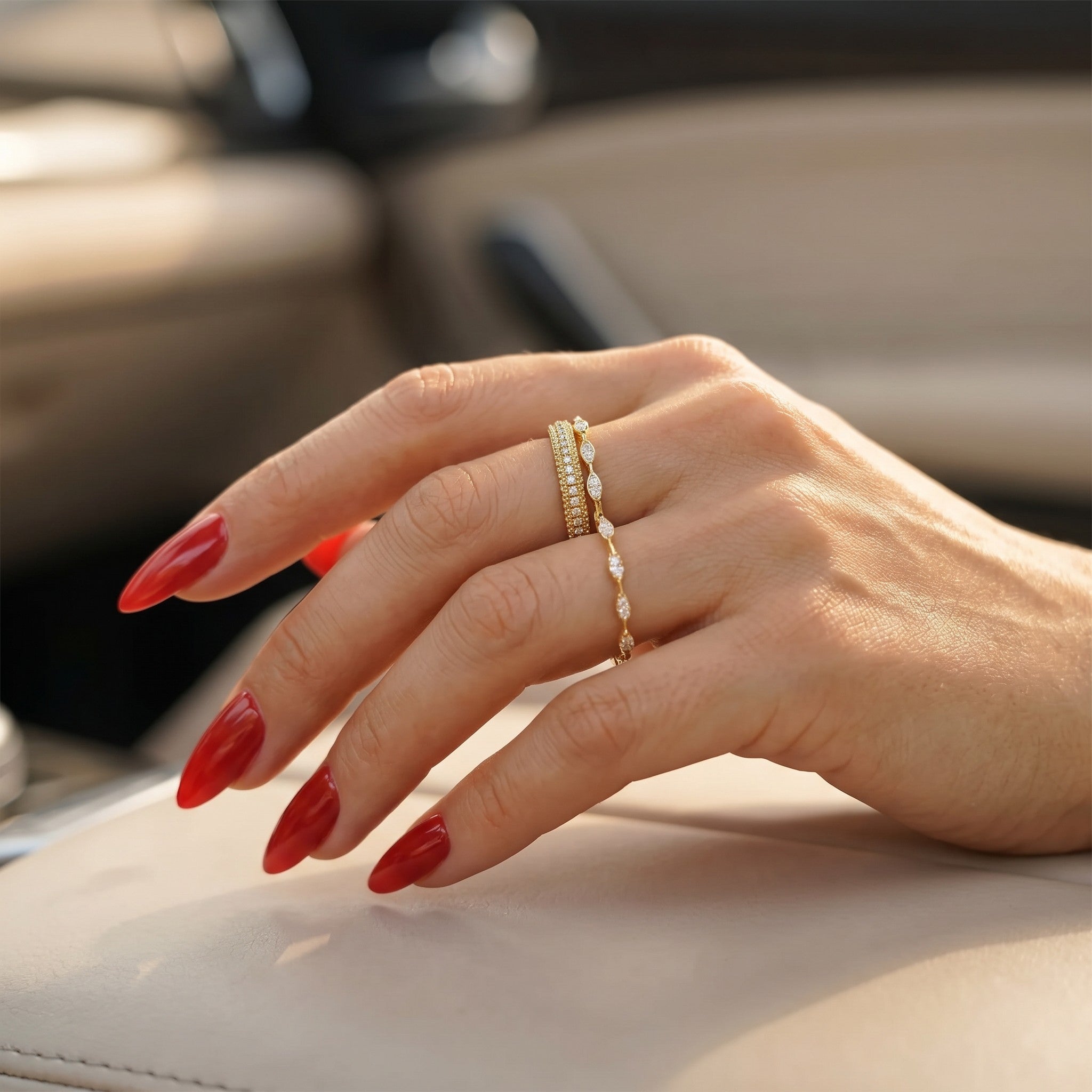 Pretty Shimmering Things Camille Gleam gold-tone brass ring set with crystal accents worn on a hand with red nails.