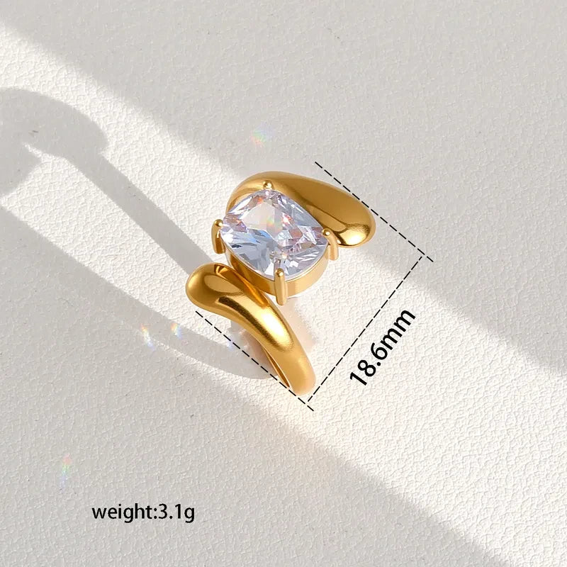 Pretty Shimmering Things gold-tone statement ring with a cushion-cut cubic zirconia stone and organic fluid band.