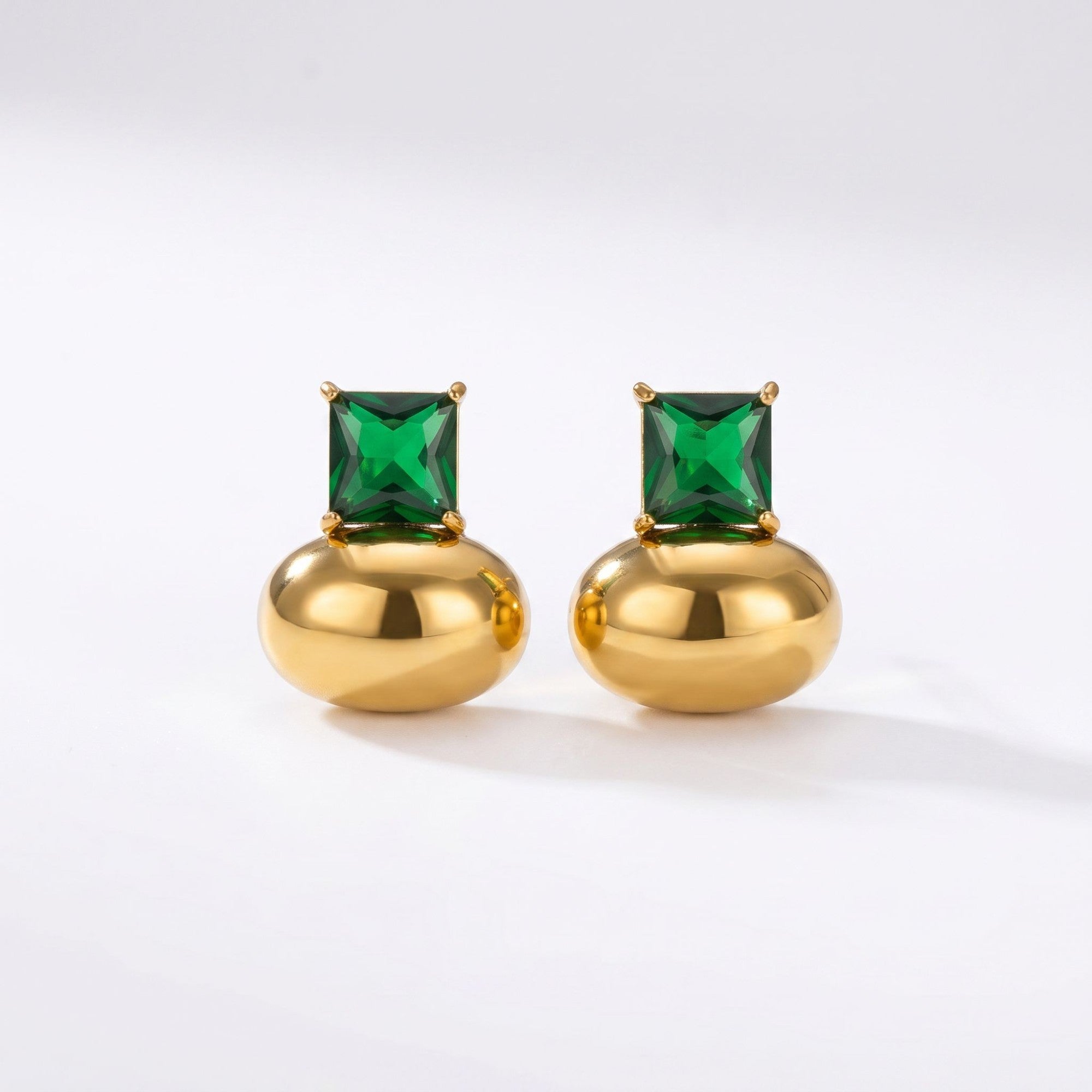 Pretty Shimmering Things gold-tone stud earrings featuring a polished metallic base and a square-cut emerald green crystal.