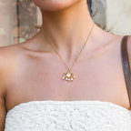 Pretty Shimmering Things gold-tone stainless steel evil eye necklace with central crystal and dangling faux pearls.