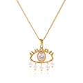 Pretty Shimmering Things gold-tone stainless steel evil eye necklace with a central crystal and dangling faux pearls.