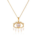 Pretty Shimmering Things gold-tone stainless steel evil eye necklace with a central crystal and dangling faux pearls.