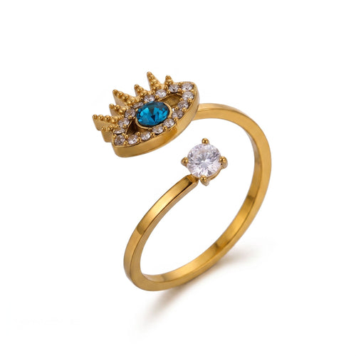 Pretty Shimmering Things gold-tone open band ring featuring an evil eye motif with a blue stone and clear crystals.
