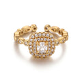 Pretty Shimmering Things gold-tone adjustable halo ring with a cushion-cut center stone and sparkling cubic zirconia.