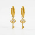 Pretty Shimmering Things gold-tone huggie hoop earrings with sparkling cubic zirconia key charms.