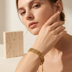 Pretty Shimmering Things gold-tone multi-strand woven stainless steel bracelet worn by a woman