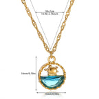 Pretty Shimmering Things gold-tone turtle pendant necklace with a faceted blue crystal and adjustable chain.